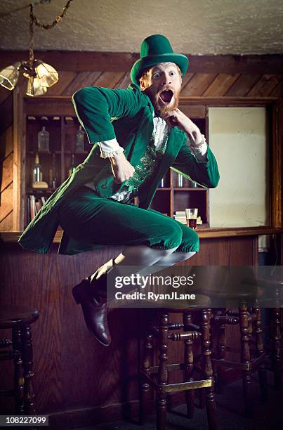 dancing irish character / leprechaun man in pub - green hat stock pictures, royalty-free photos & images
