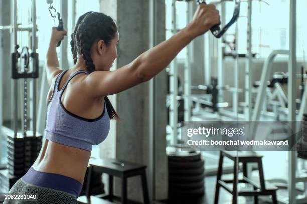 woman at the gym working out on a machine - macchina per allenamento foto e immagini stock
