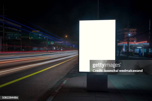 blank billboard on city street at night. outdoor advertising - billboard stock illustrations stockfoto's en -beelden