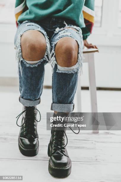 casual portrait of teenager in ripped jeans.low section - knees together fotografías e imágenes de stock