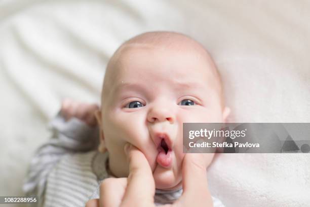 hand of mother squeezing cheeks of baby son - cheek - fotografias e filmes do acervo