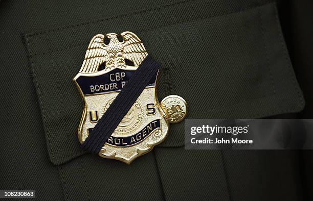 Border Patrol agent wears a black band over his badge during a memorial service for slain comrade Brian Terry on January 21, 2011 in Tucson, Arizona....