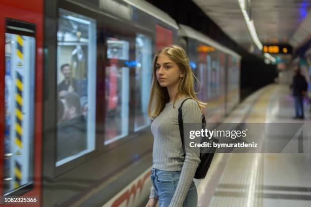 young woman waiting for the subway train - disembarking train stock pictures, royalty-free photos & images