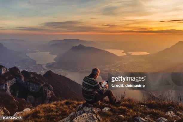 man hiker solo on the mountain during golden hour - reading imagens e fotografias de stock