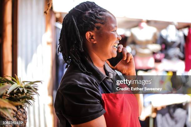 woman using her smart phone - africa mobile stock pictures, royalty-free photos & images