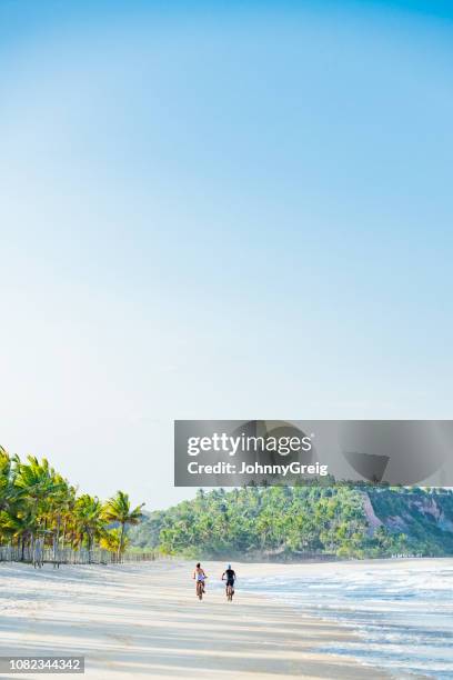 casal, andar de bicicleta na traseira vista praia - trancoso - fotografias e filmes do acervo