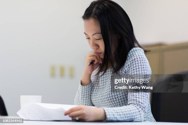 young businesswoman reviewing contracts - showus office stock pictures, royalty-free photos & images