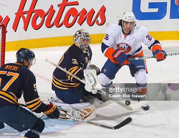 Ryan Miller of the Buffalo Sabres flips the puck to Tyler Myers and away from Matt Moulson of the New York Islanders at HSBC Arena on January 21,...