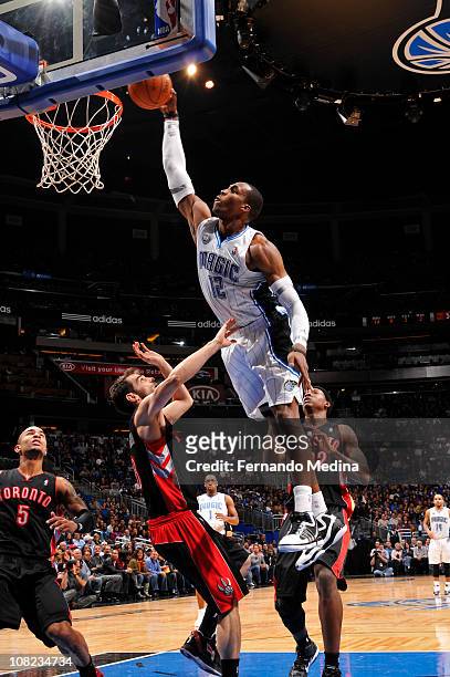 Dwight Howard of the Orlando Magic dunks against Ed Davis and Jose Calderon of the Toronto Raptors on January 21, 2011 at the Amway Center in...