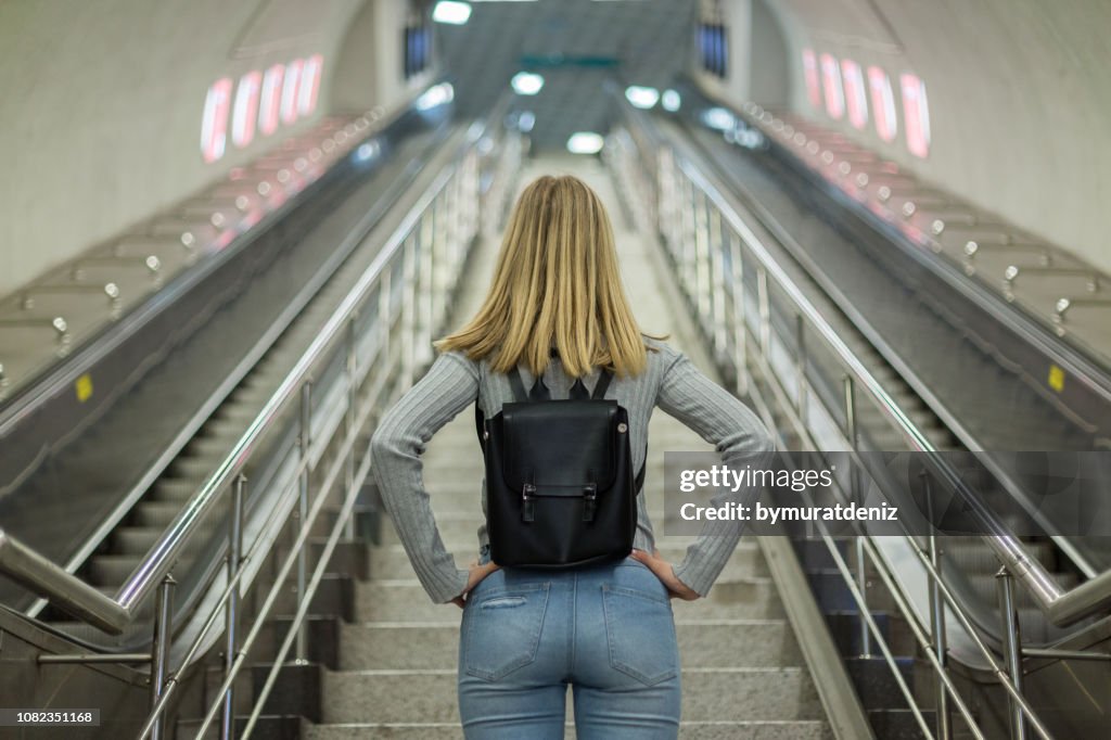 Vrouw op roltrap in metrostation