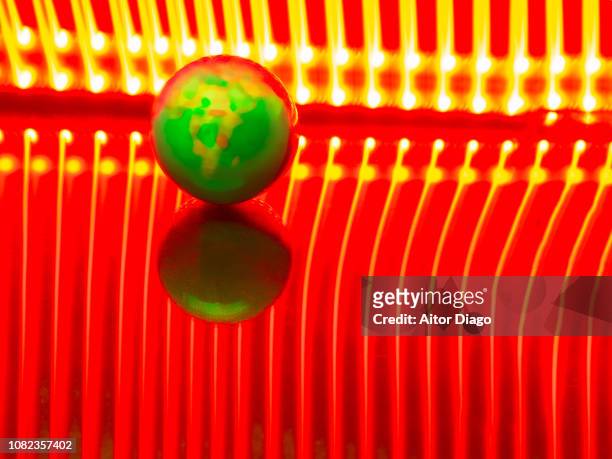 ball in the shape of earth or world map on reflective surface and red lines background. light painting. conceptual nature - mapa múndi imagens e fotografias de stock