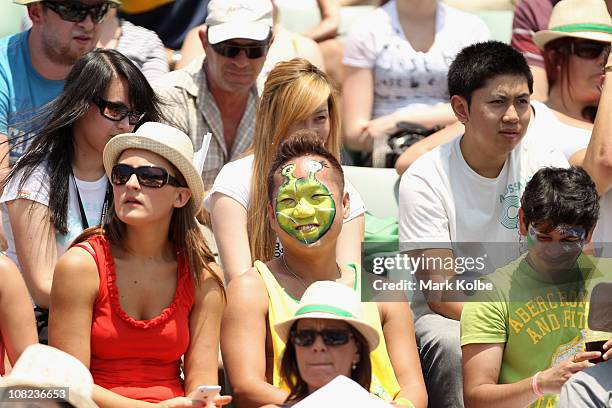 Fan has his face painted like Shrek in the crowd third round match between Mikhail Youzhny of Russia and Milos Raonic of Canada during day six of the...