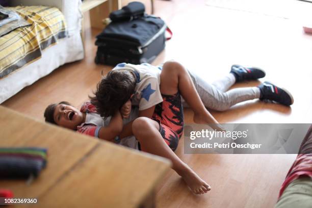 twin sisters playfully roughhousing at home. - rough housing imagens e fotografias de stock