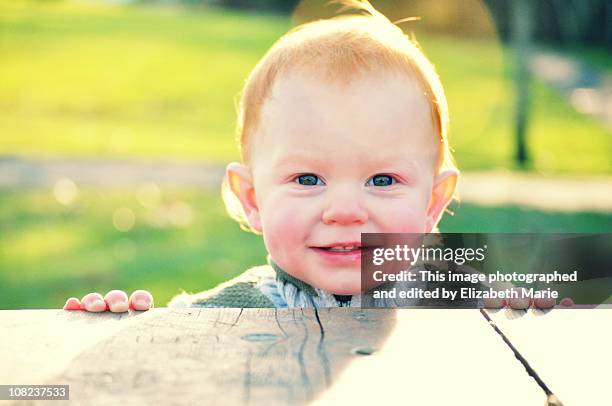 smiling baby boy outside - alleen één jongensbaby stockfoto's en -beelden