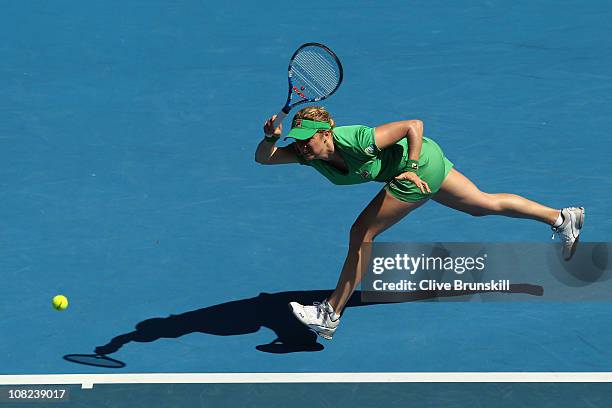 Kim Clijsters of Belgium stretches for a forehand in her third round match against Alize Cornet of France during day six of the 2011 Australian Open...