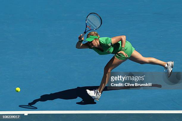 Kim Clijsters of Belgium stretches for a forehand in her third round match against Alize Cornet of France during day six of the 2011 Australian Open...