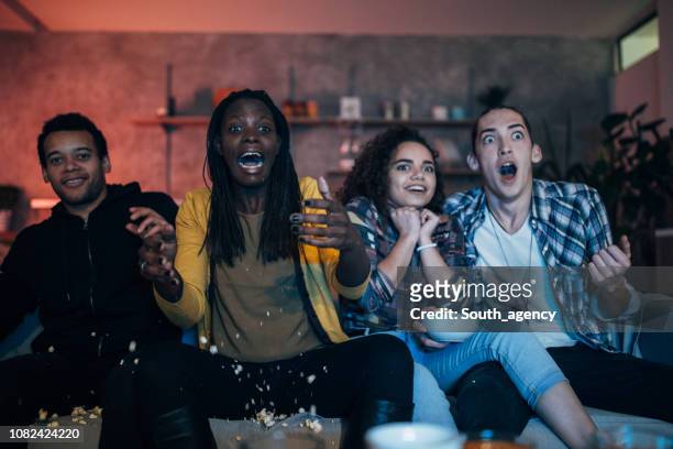 friends watching scary movie - watching stock pictures, royalty-free photos & images
