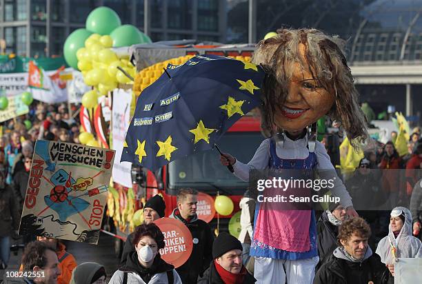 An activist on stilts dressed as an effigy of German Agriculture and Consumer Protection Minister Ilse Aigner joins a march against the agricultural...