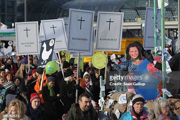 Activists holding signs to symbolize the closure of German small farms participate in a march against the agricultural industry on January 22, 2011...