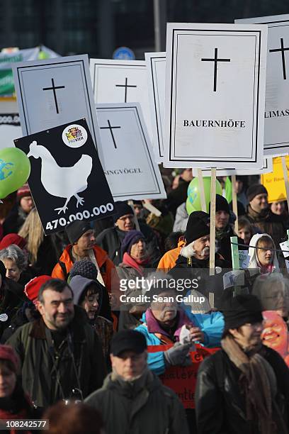 Activists holding signs to symbolize the closure of German small farms participate in a march against the agricultural industry on January 22, 2011...