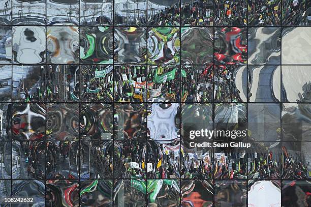 Activists marching in a demonstration against the agricultural industry are reflected in an office building's glass facade on January 22, 2011 in...