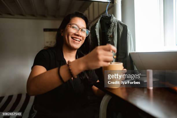 young filipino woman making coffee in her college dorm room - pinoy 個照片及圖片檔
