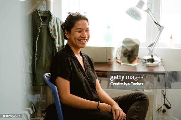 young filipino student sitting in her dorm room - フィリピン人 ストックフォトと画像