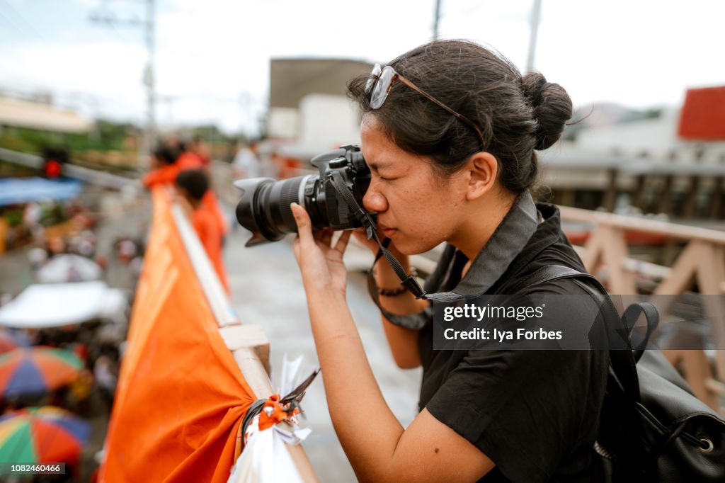 Young Filipino student photojournalist taking photographs
