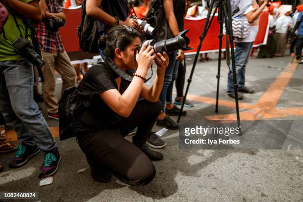 young filipino student photojournalist taking photographs - photojournalist stock pictures, royalty-free photos & images