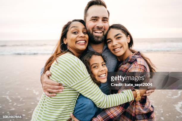 笑顔の 2 人の子供と両親 - 家族　幸せ ストックフォトと画像