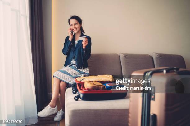 turista in camera d'albergo che effettua la prenotazione della carta di credito per il volo - booking hotel foto e immagini stock