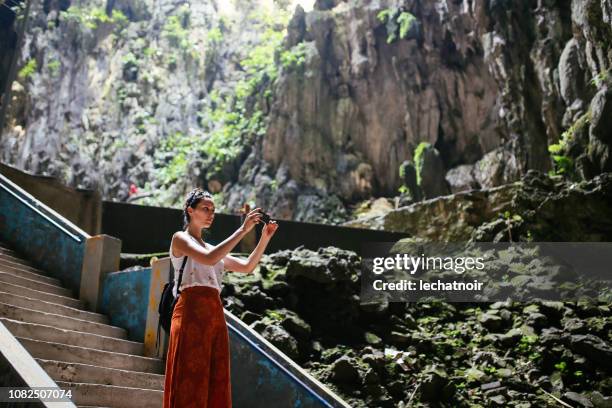 solo la mujer del viajero en las cuevas de batu en malasia, tomar una foto con su teléfono celular - estado de selangor fotografías e imágenes de stock
