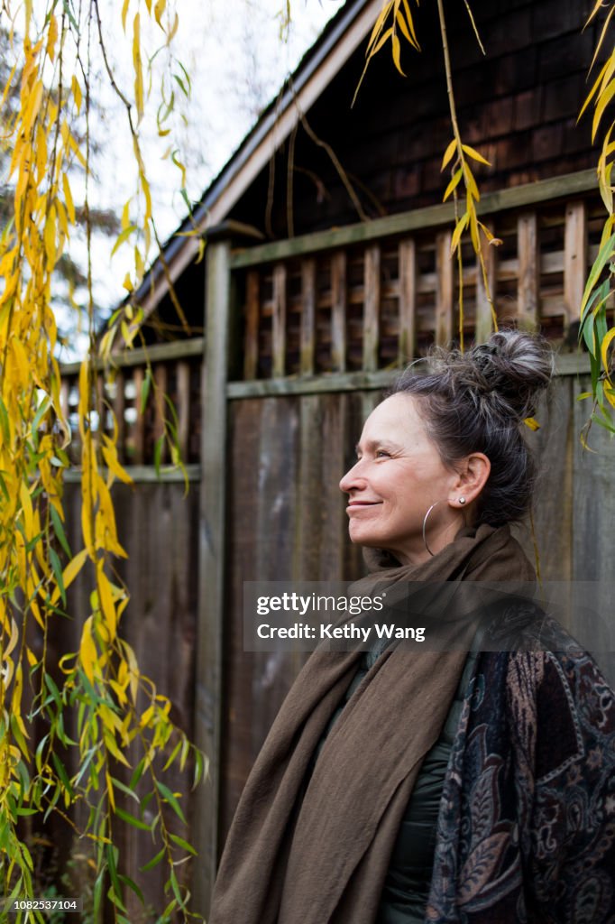 Fashionable older woman under a willow tree