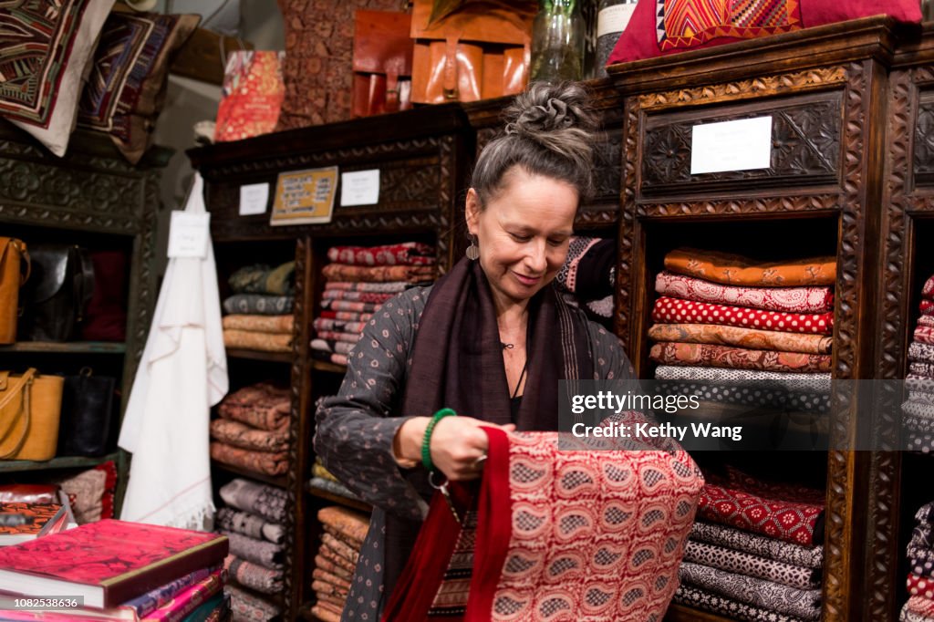 Fashionable older woman organizing merchandise