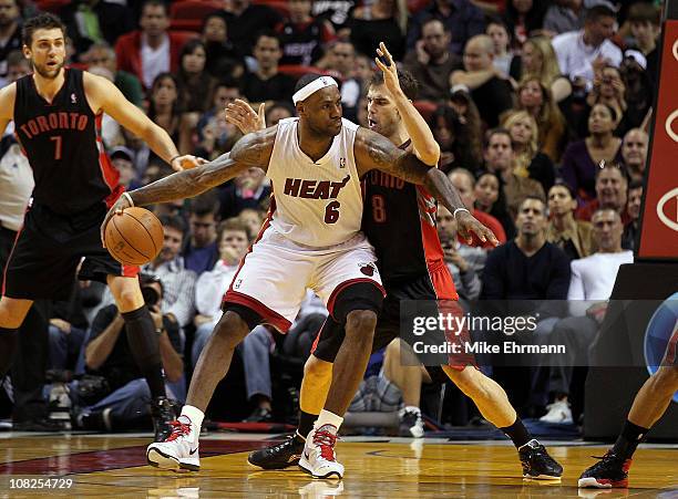LeBron James of the Miami Heat posts up Jose Calderon of the Toronto Raptors during a game at American Airlines Arena on January 22, 2011 in Miami,...