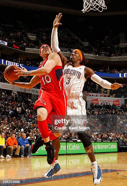 Mike Bibby of the Atlanta Hawks shoots against Gerald Wallace of the Charlotte Bobcats on January 22, 2011 at Time Warner Cable Arena in Charlotte,...