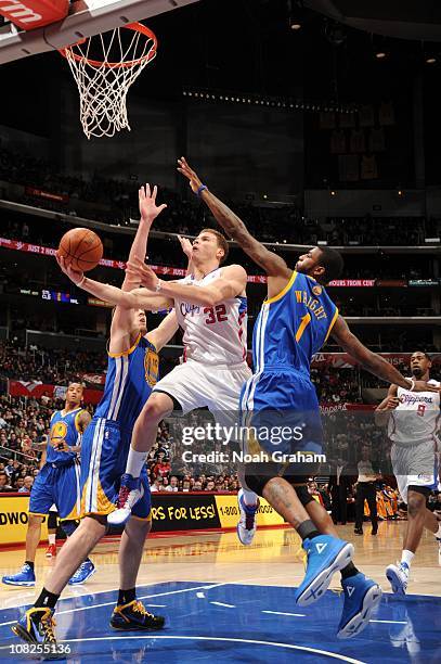 Blake Griffin of the Los Angeles Clippers goes up for a shot between David Lee and Dorell Wright of the Golden State Warriors at Staples Center on...