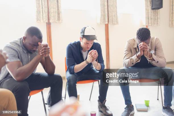 Men praying with rosaries in prayer group