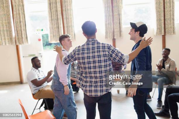 men talking and clapping in group therapy in community center - promises rehab center bildbanksfoton och bilder