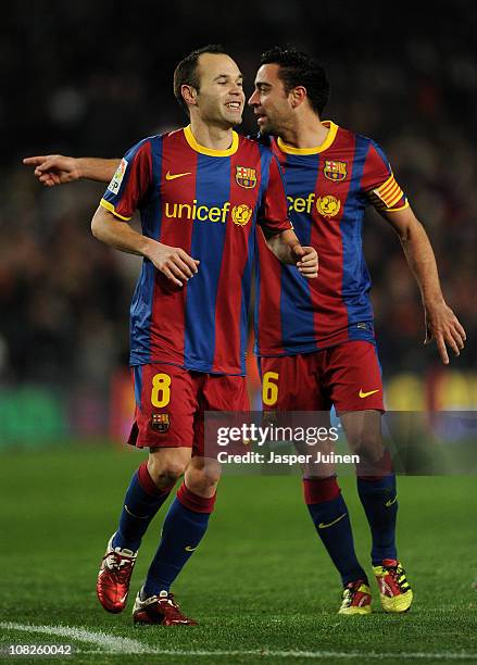 Andres Iniesta of Barcelona runs past his teammate Xavi Hernandez after scoring his sides third goal during the la liga match between Barcelona and...