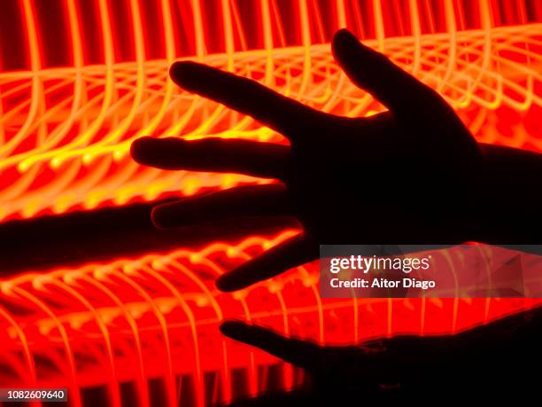 open hand reflected on reflective surface. the red and yellow lines of the background give a sensation of heat, fire. light painting. conceptual nature - disconnect filme imagens e fotografias de stock