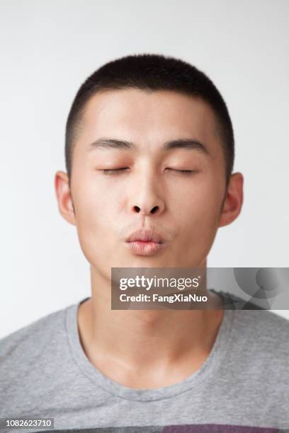 chinese man puckering his lips - puckering stock pictures, royalty-free photos & images