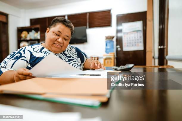 differently abled filipino woman reading documents in office - see things differently imagens e fotografias de stock