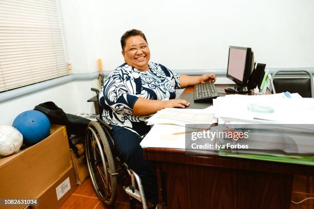 differently abled filipino woman using the computer at the office - philippines women fotografías e imágenes de stock