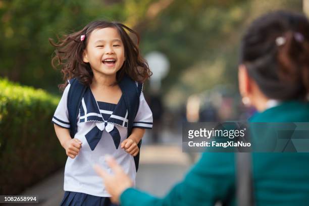 chinese daughter running to greet her mother - picking up kids stock pictures, royalty-free photos & images
