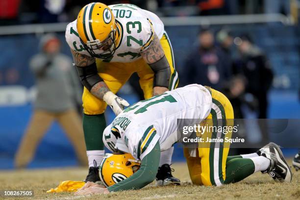 Quarterback Aaron Rodgers of the Green Bay Packers lays on the turf after getting hit by Julius Peppers of the Chicago Bears in the helmet as Peppers...