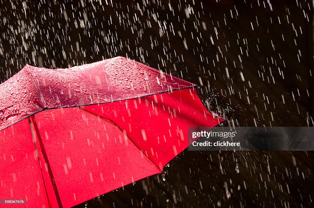 Vermelhos Guarda-chuva e da chuva contra fundo preto