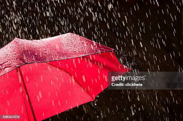 vermelhos guarda-chuva e da chuva contra fundo preto - chapéu vermelho imagens e fotografias de stock