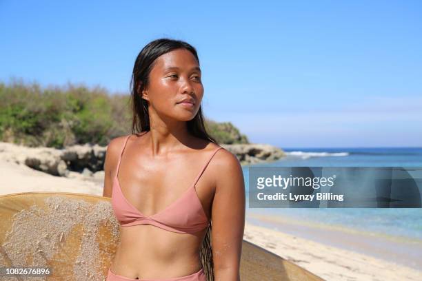 young woman with surf board at the beach in the sun - hot filipina women stock pictures, royalty-free photos & images
