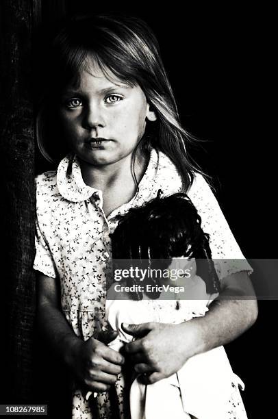 black and white portrait of a girl holding a doll - alleen één meisje stockfoto's en -beelden